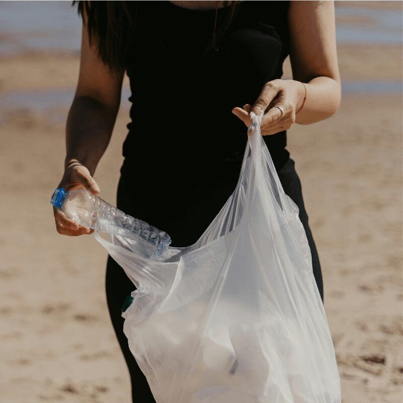 picking up plastic trash on the beach