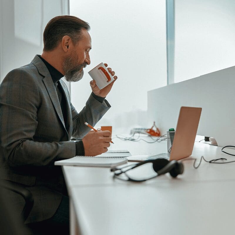 businessman drinking from a cup at his desk